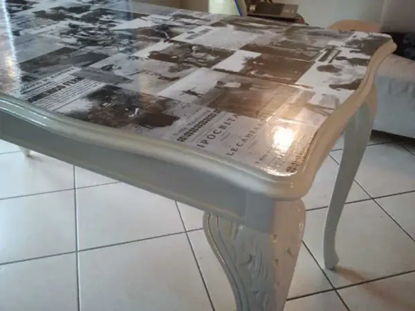 Tavolo antico trasformato con collage di giornali d'epoca sotto resina trasparente: un modo moderno per dare nuova vita ai mobili.