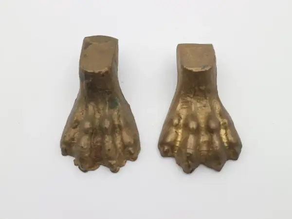 Due elementi in bronzo a forma di zampa di leone, tipici dell'epoca dei mobili con questo dettaglio.