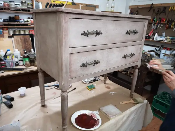 Un mobile antico in fase di restauro in stile shabby. Pennelli, colori e materiali pronti per trasformare un vecchio mobile.