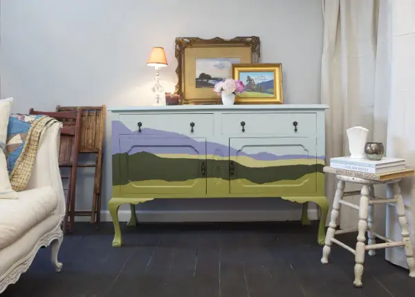 Mobile antico dipinto con paesaggio stilizzato, un'idea per mobili antichi colorati che porta un tocco di natura in casa.