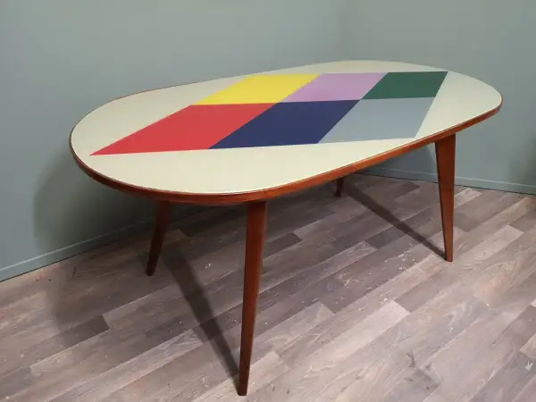 Tavolino anni '70 con piano ovale decorato a rombi colorati. Un esempio di come rinnovare mobili anni 70 con stile.