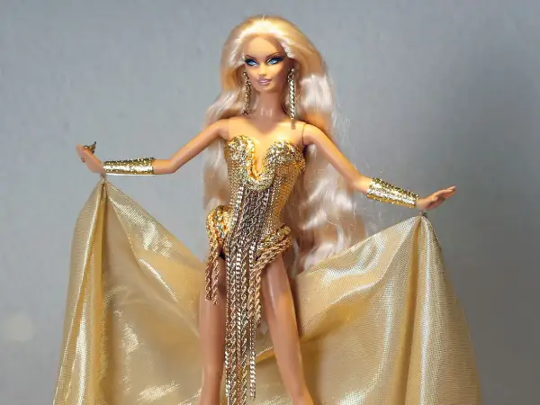 Barbie con abito dorato scintillante, bracciali e orecchini. Potrebbe essere la barbie più costosa al mondo, un vero tesoro.