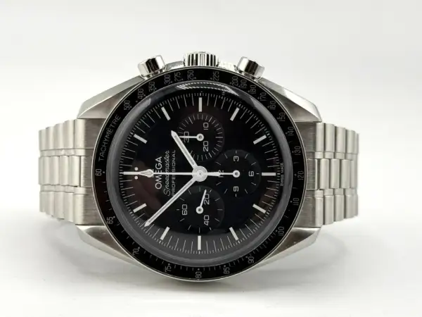 Orologio Omega Speedmaster con quadrante nero e cinturino in metallo, protetto da un **vetro esalite** che cattura la luce.