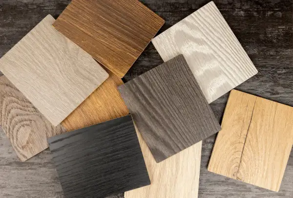 Campioni di **colori legno naturali** con venature evidenti: nero, grigio, beige, marrone chiaro e scuro, e un tono più caldo.
